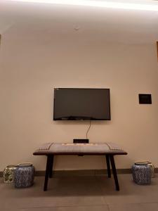 a flat screen tv on a wall with a table at Terra Cottage in Jāmb