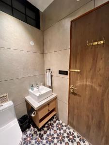 a bathroom with a sink and a wooden door at Terra Cottage in Jāmb