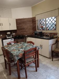 una cucina con tavolo e sedie e una cucina con piano cottura di Golden sunshine a Paralimni