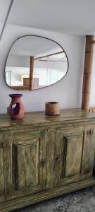 eine hölzerne Kommode mit einem Spiegel darüber in der Unterkunft Vila Paisagem in Barra de Guaratiba