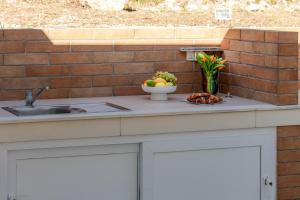eine Küchentheke mit einer Obstschale und einer Spüle in der Unterkunft Silvio Beach House - Shoreline Haven in Mlini