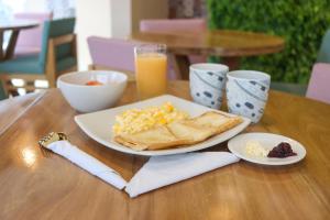 a plate of breakfast food on a wooden table at Balcones de la Quinta in Ríohacha