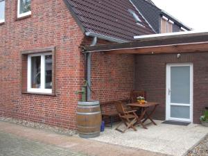 a brick building with a patio with a table and a barrel at Daisy 78 in Wilhelmshaven
