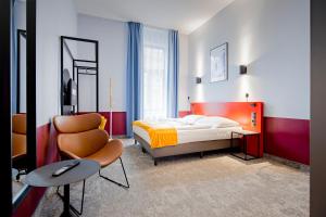 a bedroom with a bed and a chair at Maverick Athenaeum in Budapest