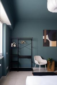 une chambre avec une chaise et un mur bleu dans l'établissement L'Atelier - 2 min walk to Bernina Express, à Tirano 25 autres photos