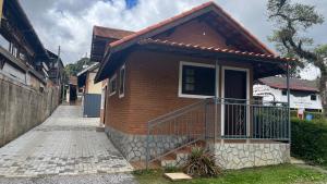 ein kleines Backsteinhaus mit Balkon an einer Straße in der Unterkunft Chalés Ipe Amarelo in Camanducaia