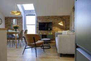un salon avec un canapé et une table avec des chaises dans l'établissement Apartament Na Urlop - Wisła - Magiczny Horyzont, à Wisła