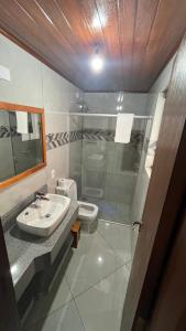 ein Badezimmer mit Waschbecken, Dusche und Toilette in der Unterkunft Chalés Ipe Amarelo in Camanducaia + 20 Fotos