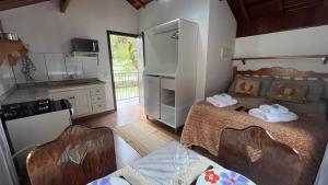 eine kleine Küche mit einem Bett in einem Zimmer in der Unterkunft Chalés Ipe Amarelo in Camanducaia