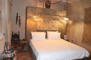ein Schlafzimmer mit einem weißen Bett mit großem Kopfteil in der Unterkunft BIOtorisme-chama in Taroudant + 145 Fotos