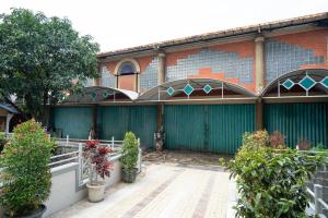 Un edificio con una valla verde y algunas plantas. en ARA Stay By ARBA, en Bandung