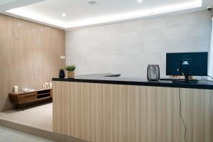Un vestíbulo de oficina con un mostrador con una computadora encima en ARA Stay By ARBA, en Bandung
