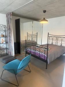 Un dormitorio con una cama y una silla azul. en Luxury Studio Happy Life, en Blumenstein