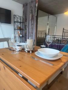Una mesa de madera con un plato y copas de vino encima. en Luxury Studio Happy Life, en Blumenstein 7 fotos más