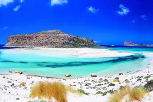 a beach with blue water and a mountain in the background at Perla Nera Villa Mit Privatem Beheiztem Pool in Kávallos