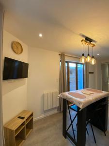 eine Küche mit einem Tisch und einer Uhr an der Wand in der Unterkunft Appartement calme à Saint Maixent l'Ecole in Saint-Maixent-lʼÉcole