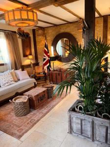 a living room with a couch and a plant at Dovecote Cotswold Cottages in Chipping Norton
