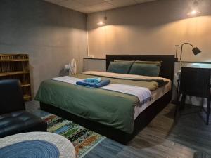 a bedroom with a bed and a chair and a table at Baan Koody Hostel in Ko Kut