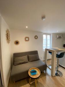ein Wohnzimmer mit Sofa und Tisch in der Unterkunft Appartement calme à Saint Maixent l'Ecole in Saint-Maixent-lʼÉcole