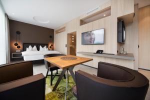 a hotel room with a bed and a table and chairs at Boutiquehotel WEINSPITZ & Weingut STRAWANZER Donabaum in Spitz