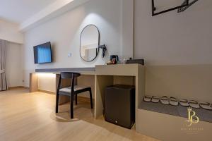 Una habitación con un tocador con espejo y un escritorio. en The Bentley Hotel, en Bangkok