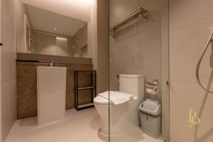 Un baño con inodoro y cabina de ducha de cristal. en The Bentley Hotel, en Bangkok