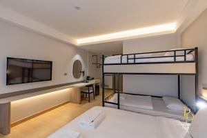 Un dormitorio con dos literas y un escritorio. en The Bentley Hotel, en Bangkok 105 fotos más