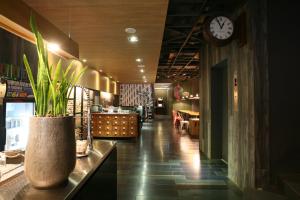 un restaurante con un reloj en la pared y un vestíbulo en P&F Hotel en Taichung