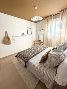 a bedroom with a bed with pillows and a window at Beautiful 2 bedroom apartment with pool in Saint Florent in Oletta +59 photos