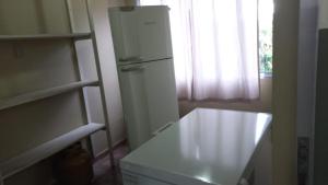 a white refrigerator in a kitchen with a window at Chácara do Sossego in Piracaia