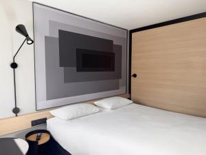 a bedroom with a bed with a large picture on the wall at ibis Nîmes Ouest - A9 in Nîmes +51 photos