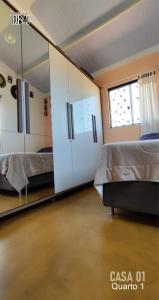 a bedroom with two beds and a mirror at Chalé tribal Vermelho in Alto Paraíso de Goiás