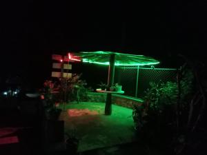 eine Terrasse mit einem grünen Sonnenschirm bei Nacht in der Unterkunft Diyatalawa Mountain Holiday Resorts in Diyatalawa