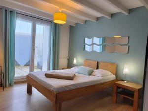 une chambre avec un lit et une grande fenêtre dans l'établissement Villa 1893, à Le Pavé