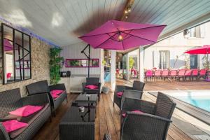 un restaurant avec des coussins et des chaises roses et une piscine dans l'établissement Villa 1893, à Le Pavé