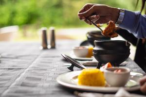 a person eating food on a table with plates of food at AfriCamps Champagne Valley in Champagne Valley