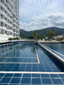 圣玛尔塔Frente al mar ,vista panoramica, acceso a la playa的大楼内一个蓝色瓷砖游泳池