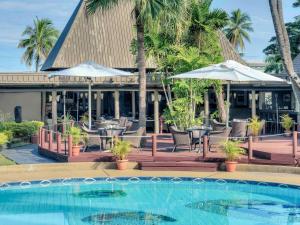 a resort with a pool and chairs and umbrellas at Mercure Nadi in Nadi