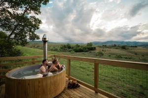 two people sitting in a hot tub on a deck at AfriCamps Champagne Valley in Champagne Valley +11 photos