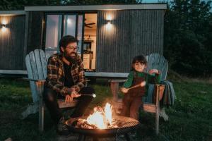 蒙托邦Parcel Fonneuve Les Crins的坐在火炉旁的男人和孩子