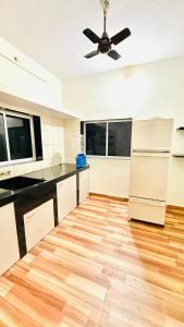 a kitchen with a ceiling fan and a wooden floor at Coco villa in Pālghar +20 photos