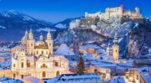 uma cidade com edifícios cobertos de neve e uma montanha em Ferienwohnung Moorblick em Koppl