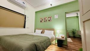 a bedroom with a bed and a green wall at Coco villa in Pālghar