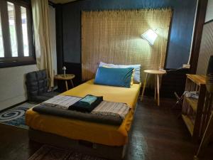 a hotel room with a bed and a chair at Baan Koody Hostel in Ko Kut