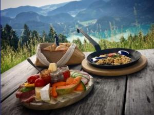 uma mesa com um prato de alimentos e uma panela de alimentos em Ferienwohnung Moorblick em Koppl