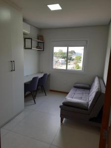 a room with a bed and a desk and a window at Meu lar na Serra Gaúcha in Nova Petrópolis
