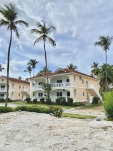 a large house on the beach with palm trees at Beautiful second floor apartment with loft 5D in El Francés