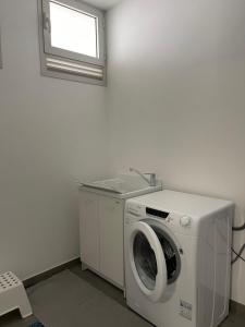 a washing machine in a room with a window at Villa Malù in Lignano Sabbiadoro