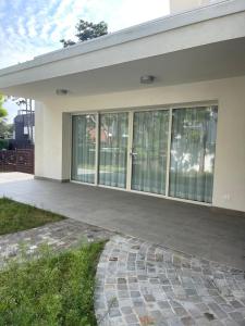 a building with large glass windows and a sidewalk at Villa Malù in Lignano Sabbiadoro