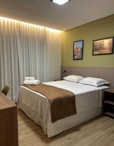 a bedroom with a large bed with white sheets at Belém Forest Inn in Belém +17 photos
